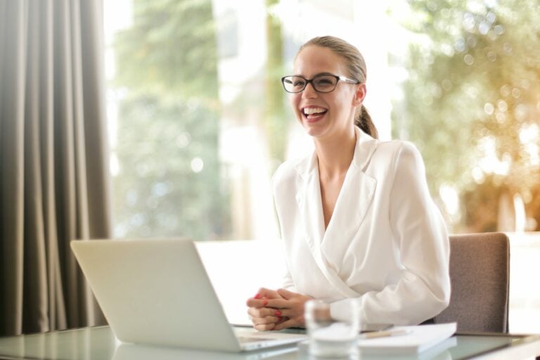 Business woman smiling in front of laptop